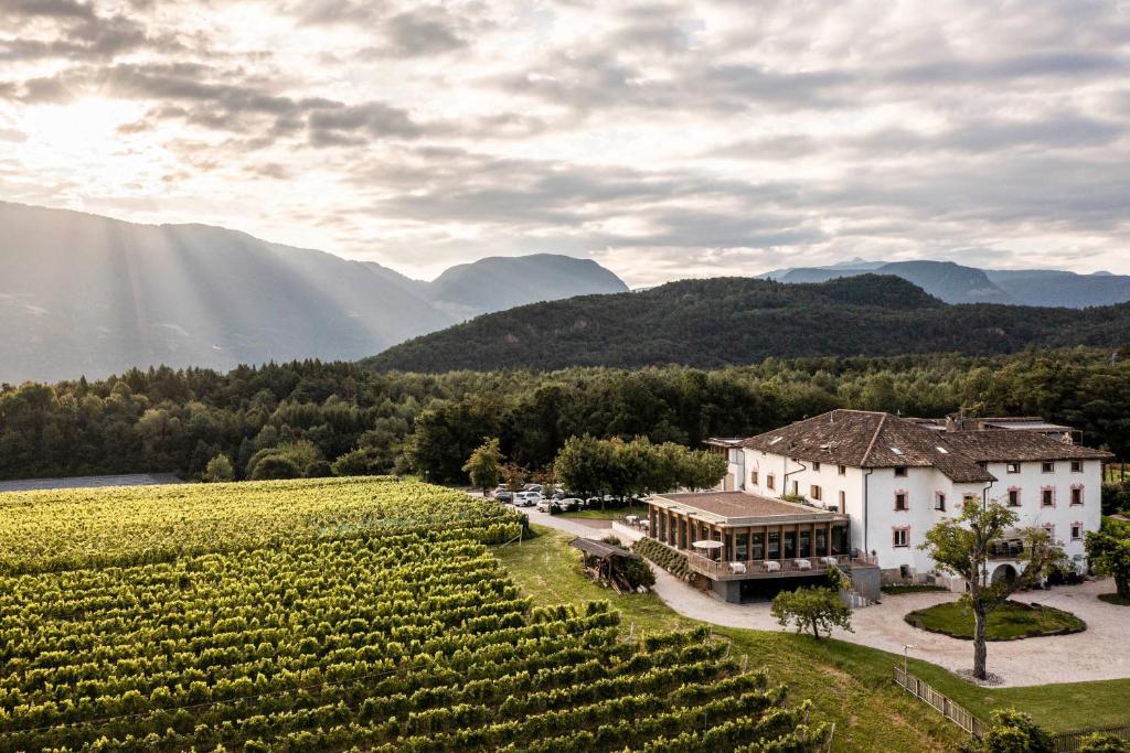 uma vista aérea de uma adega e de uma vinha em Hotel Ansitz Rungghof em Appiano sulla Strada del Vino