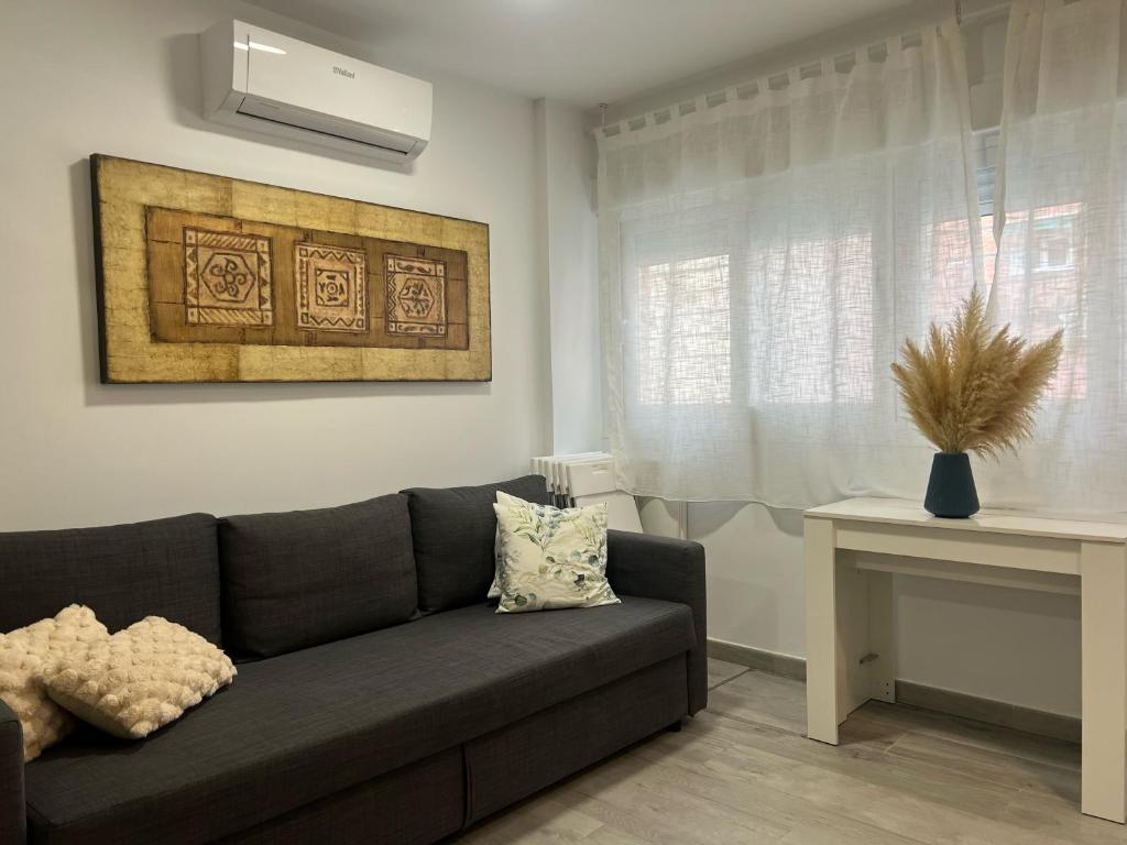 - un salon avec un canapé et une fenêtre dans l'établissement Apartamentos para 10 personas en Barrio del Pilar, à Madrid