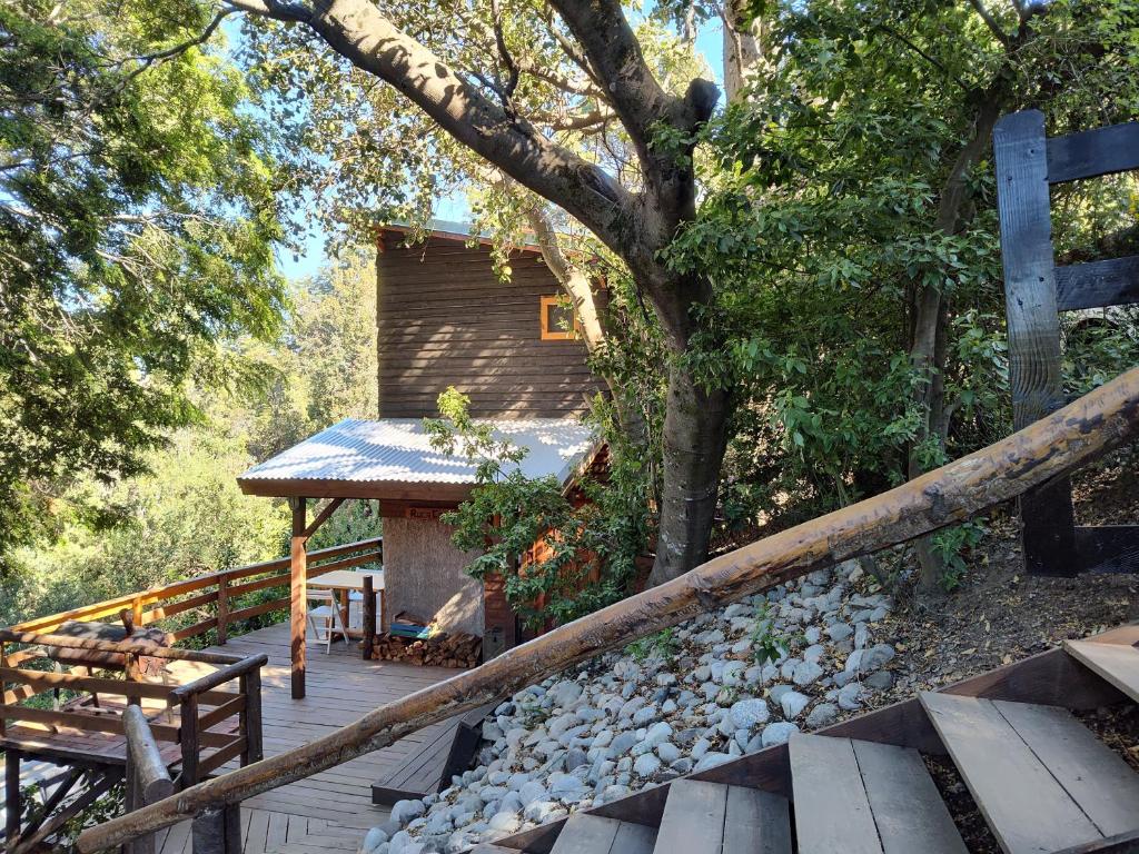 um deque de madeira com um banco e uma cabina em Cabaña de montaña Ruca Calel em San Carlos de Bariloche