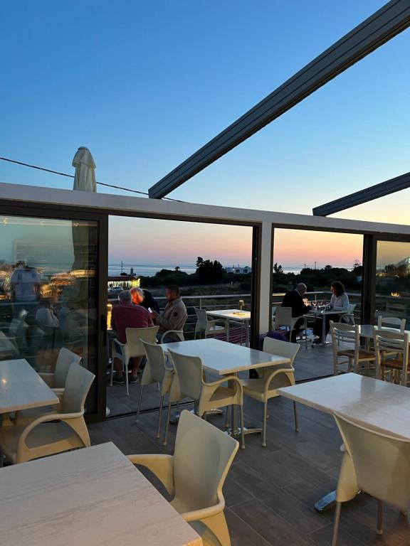 a restaurant with tables and chairs and people sitting at tables at Blue Sky in Frangokastello