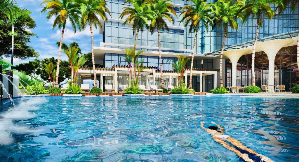 a person swimming in a pool in front of a building at Luxury 2BR with Balcony Suite 8 - City View in Manila