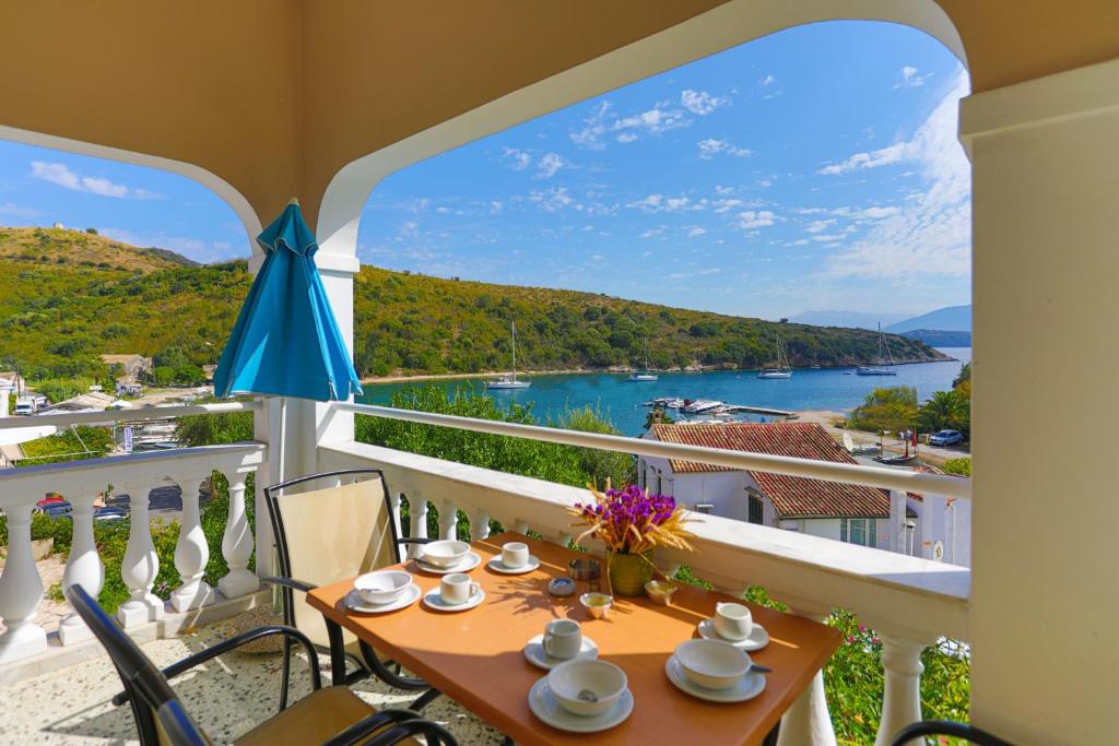 balcón con mesa, sillas y vistas al agua en Irena Saint Stephanos, en Ágios Stéfanos