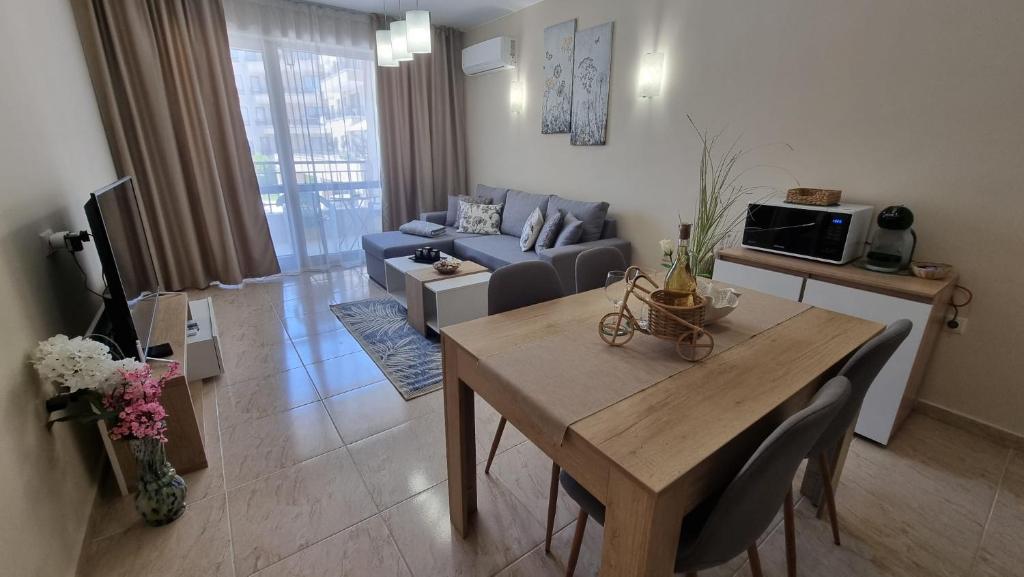 un soggiorno con un tavolo e un divano blu di Sea Dreams Sunrise Apartment a Sveti Vlas