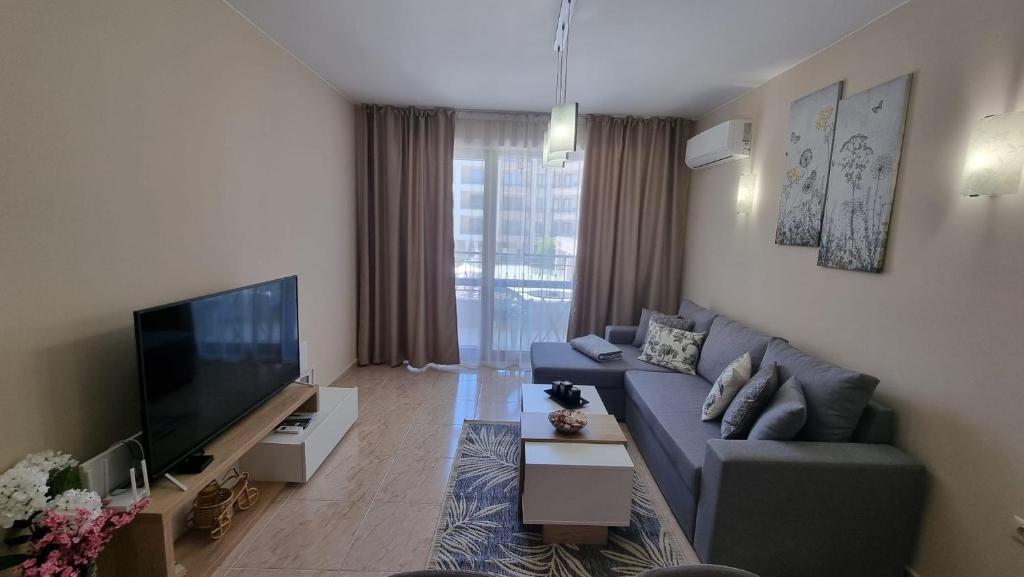 Sea Dreams Sunrise Apartment في سفيتي فلاس: غرفة معيشة مع أريكة وتلفزيون بشاشة مسطحة