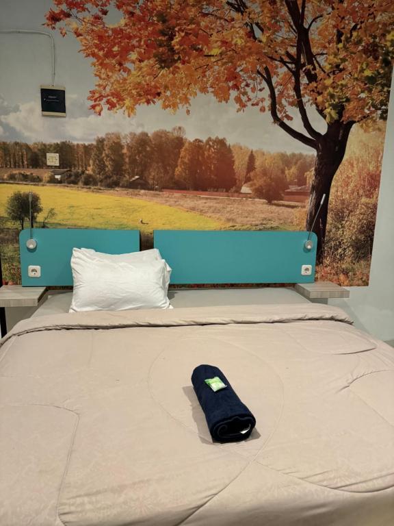 a remote control sitting on a bed in front of a tree at Cozy centre Simpang Lima Semarang in Semarang