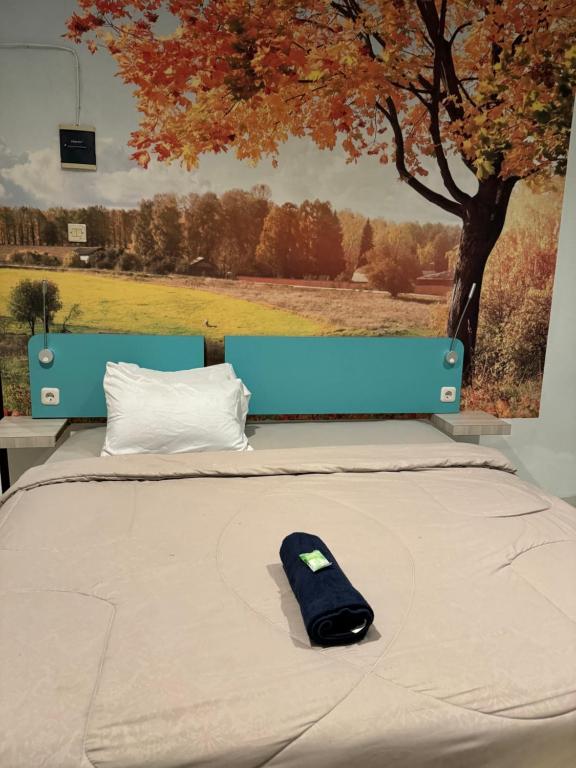 スマランにあるCozy centre Simpang Lima Semarangの木の前のベッドの上に置かれたリモコン