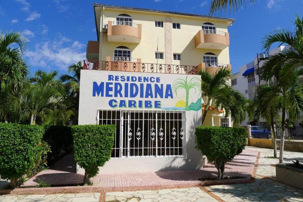un edificio con un cartel que lee residencia meridianiana care en Residence Caribe, en Guayacanes