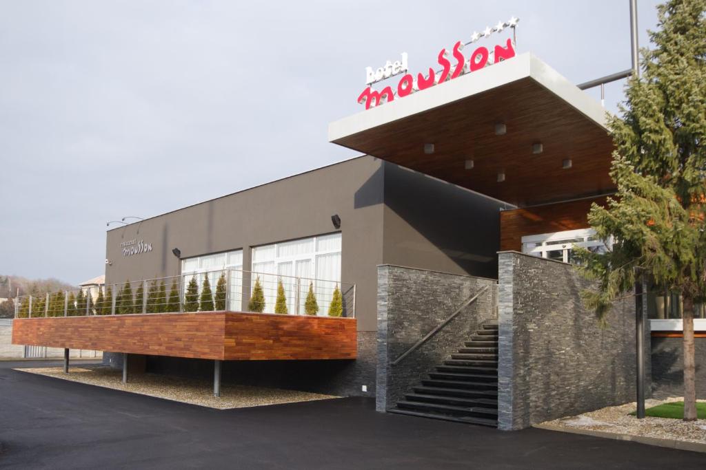 a building with a sign on the front of it at Hotel Mousson in Michalovce