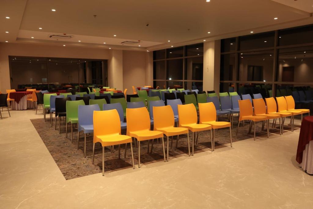 a group of chairs and tables in a room at Hotel Krystal in Sāngli
