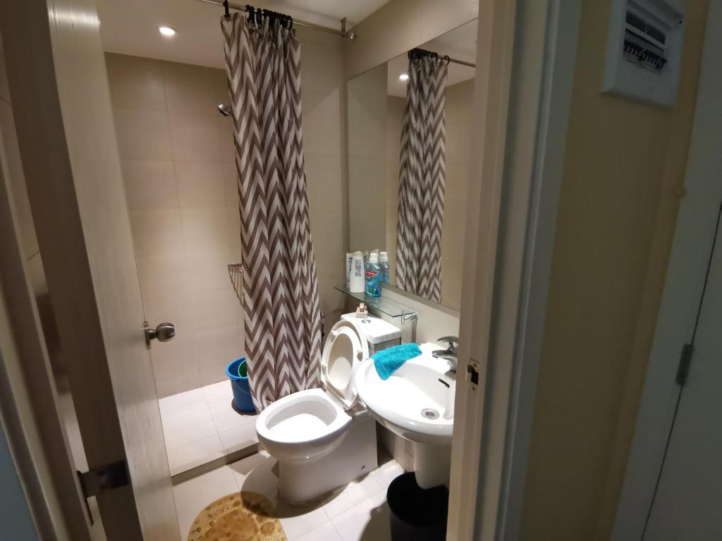 małą łazienkę z toaletą i umywalką w obiekcie Azure Urban Resort Residences w mieście Manila
