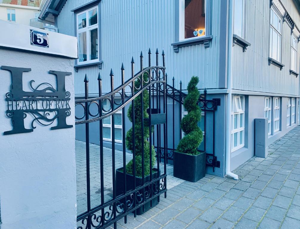 雷克雅維克的住宿－Heart of Reykjavik-Luxury Apartments，一座种植了盆栽植物的建筑旁边的黑色栅栏