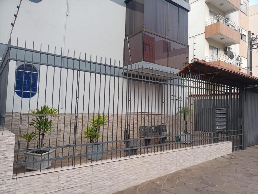 a fence in front of a building with plants at Apto em Santa Maria in Santa Maria