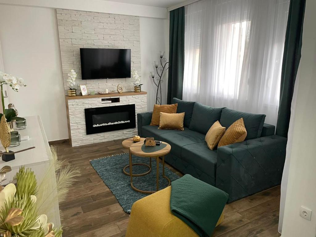 a living room with a blue couch and a fireplace at VESTA Apartman in Sremska Mitrovica