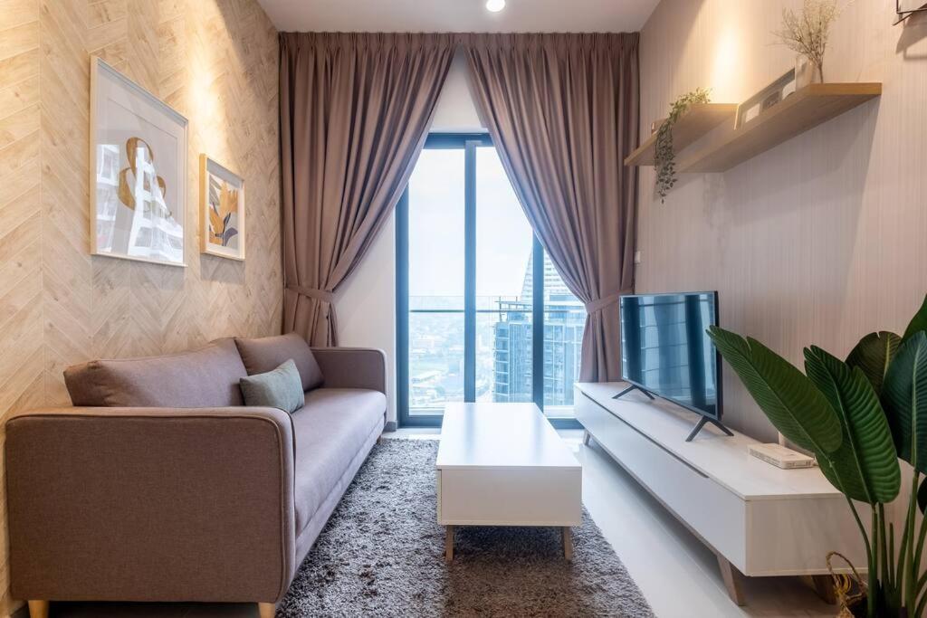 a living room with a couch and a tv at Endless Warming~ 2BR5Pax Southlink Bangsar South in Kuala Lumpur