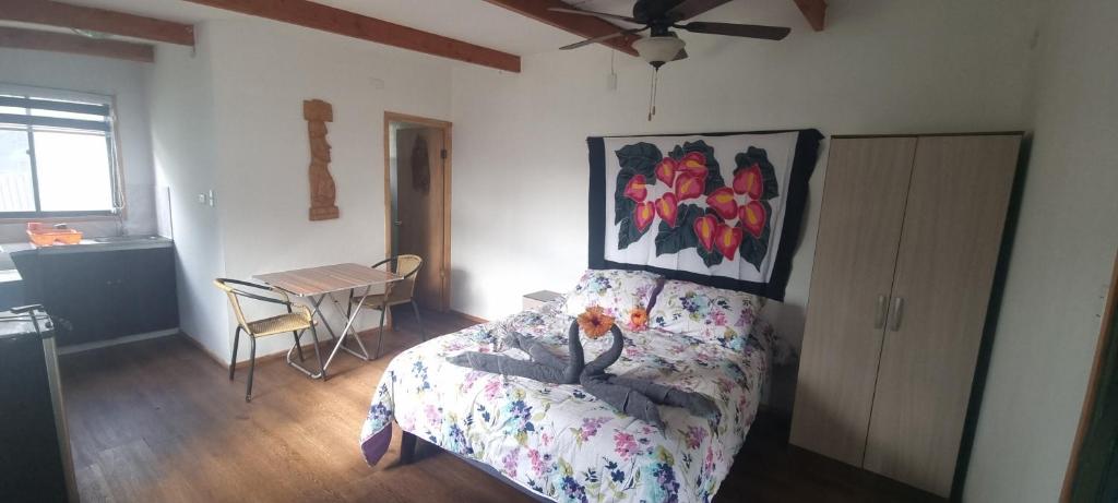 - une chambre avec un lit et une peinture murale dans l'établissement Hostal Henua Roa 2, à Hanga Roa