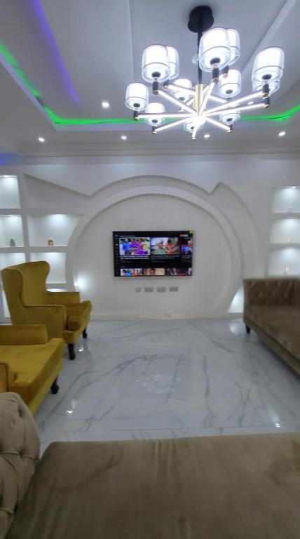 ein Wohnzimmer mit einem Sofa und einem TV an der Wand in der Unterkunft 3 bed apartments at awoyaya, ibeju lekki. Lagos. in Awoyaya