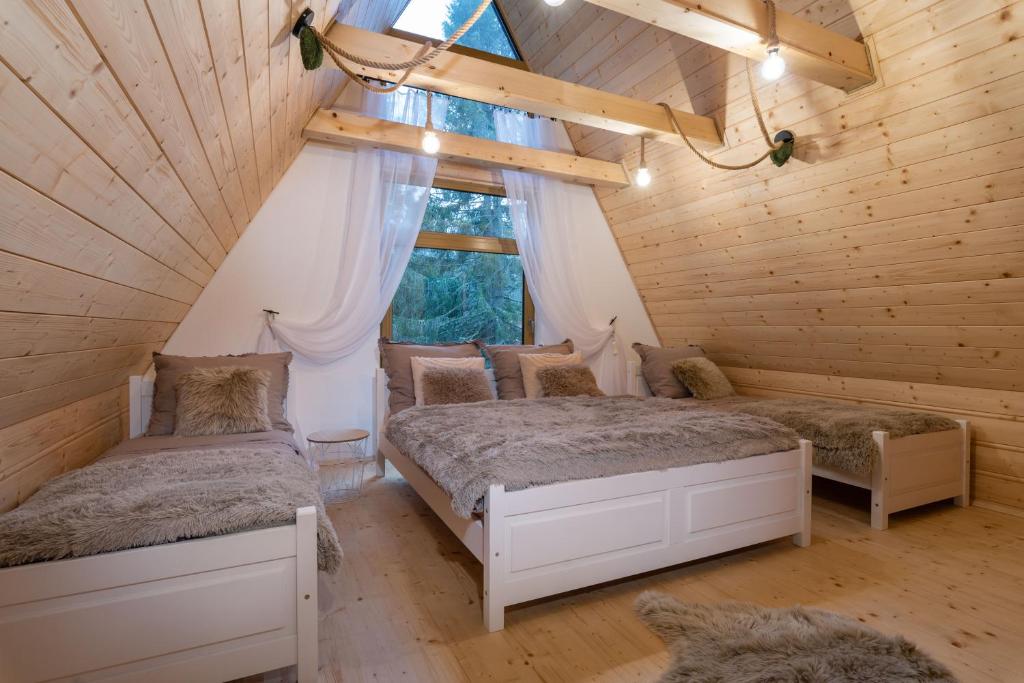 2 Betten in einem Zimmer mit Fenster in der Unterkunft Chata in Pribylina