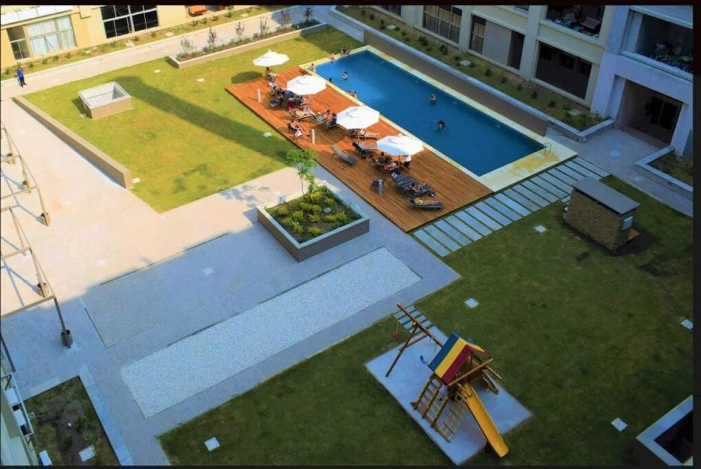 uma vista superior de uma piscina com mesas e guarda-sóis em Acogedor, inolvidable em Montevidéu