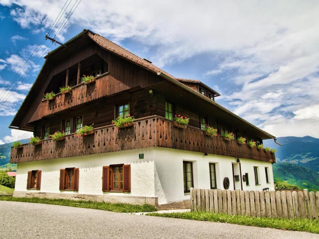 a house with a wooden roof with flowers on it at Holiday home Birkenhof in Afritz Verditz in Verditz