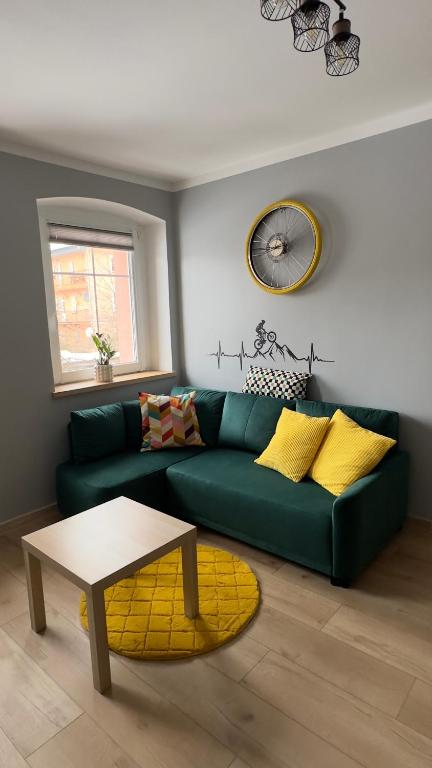 a living room with a green couch and a table at Sasanka LZ in Lądek-Zdrój