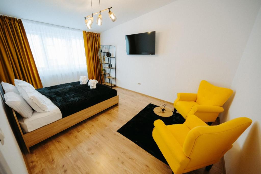 a bedroom with a bed and a yellow chair at Modern Studio in Ipoteşti
