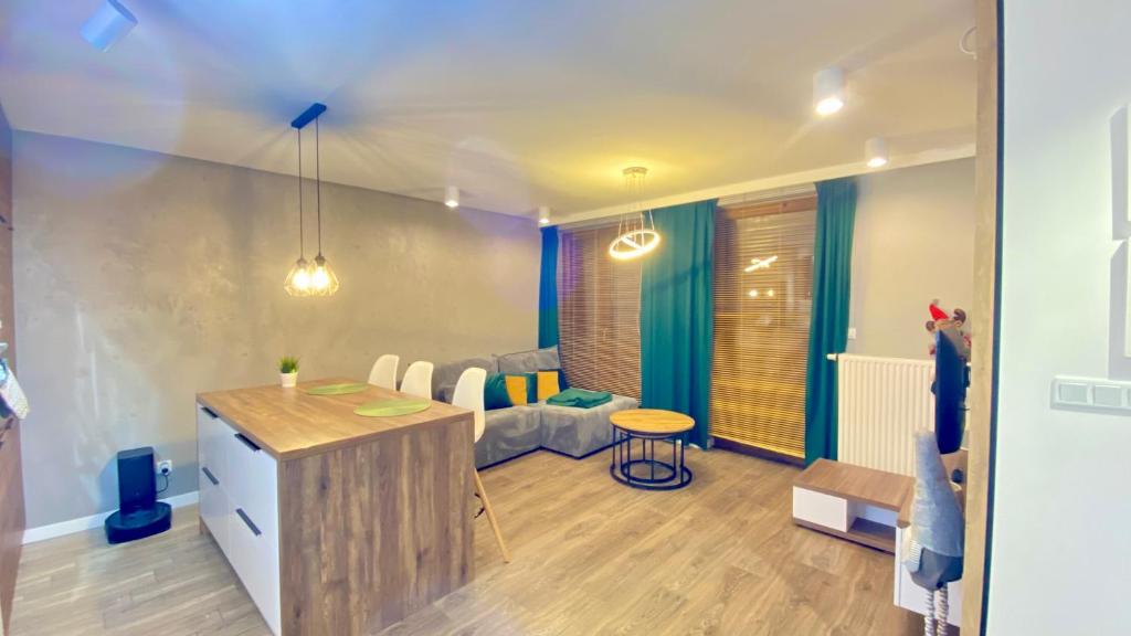 a room with a kitchen and a living room at Apartament Złocień in Krakow