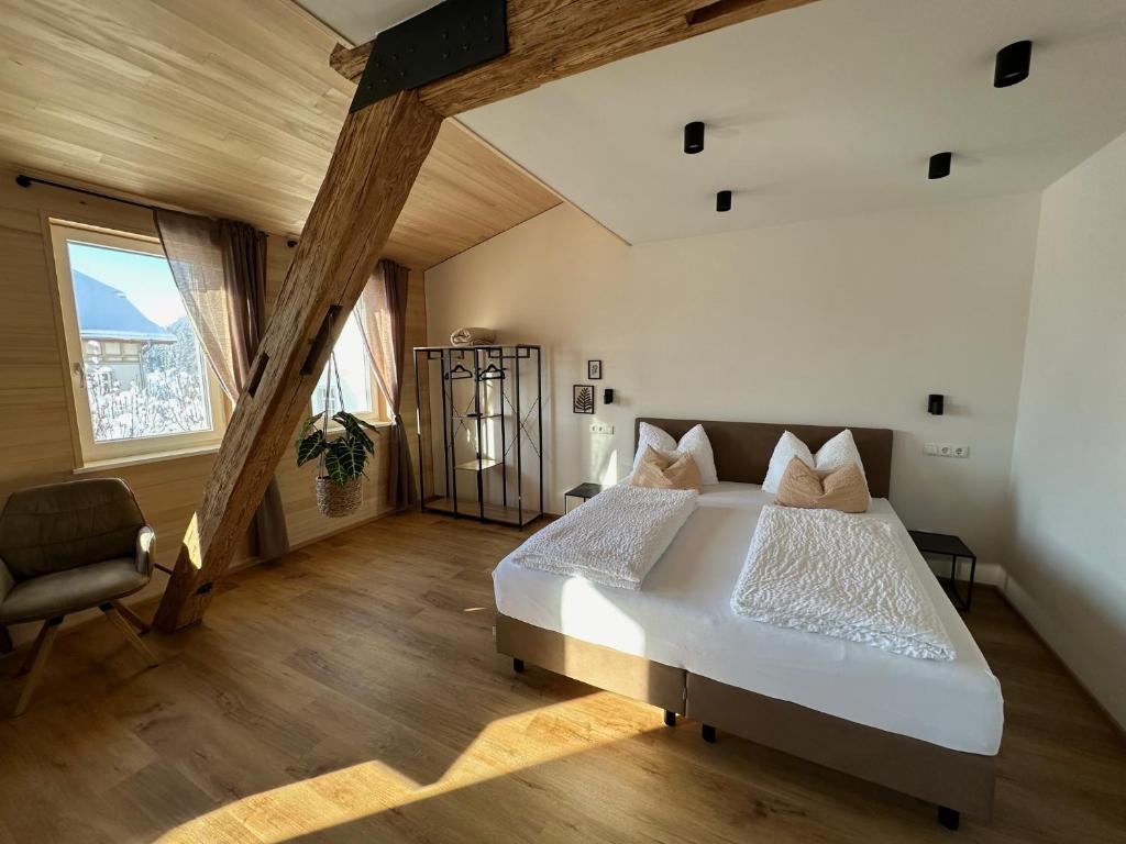 a bedroom with a large bed and a chair at Gasthof - Auszeit im Bad Diezlings - Adults only in Hörbranz