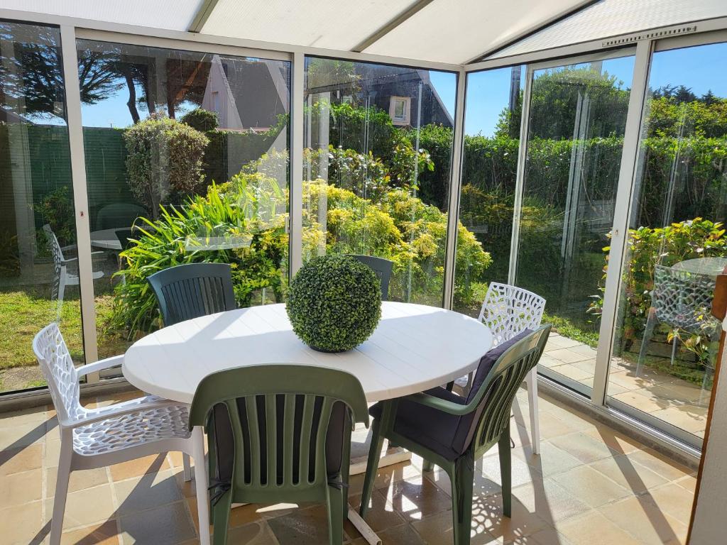 d'une terrasse avec une table et des chaises blanches. dans l'établissement Maison de KERLEVEN PLAGE, à La Forêt-Fouesnant