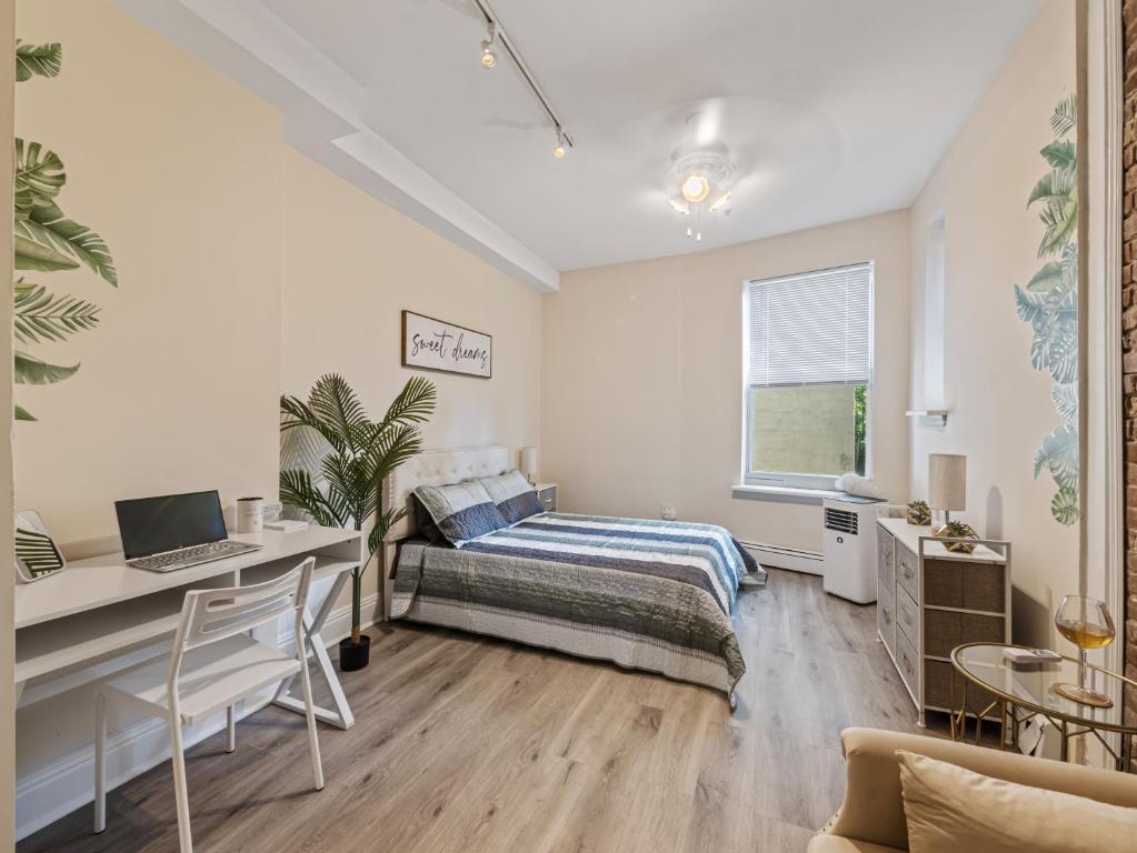 a bedroom with a bed and a desk with a laptop at Minutes to NYC Sleeps 5 in Hoboken