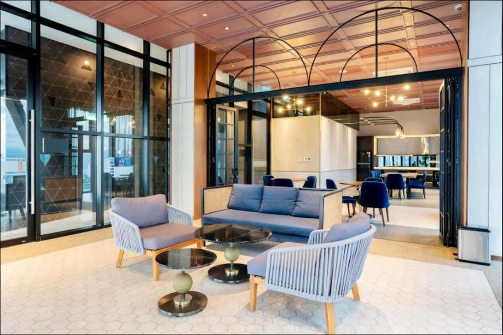 a living room with a blue couch and chairs at Scarletz Suites KLCC by M Suites in Kuala Lumpur