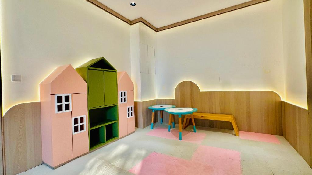 a room with a table and a toy house at Scarletz Suites KLCC by M Suites in Kuala Lumpur
