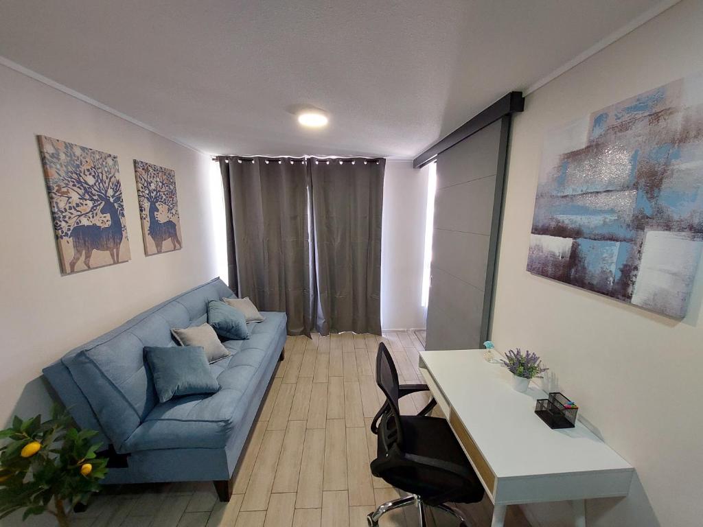 a living room with a blue couch and a table at Apartamento Santiago Caupolicán in Santiago