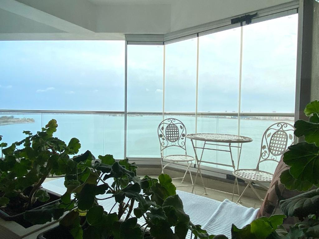 a room with a table and chairs and a large window at Lake House - Bucuresti in Bucharest