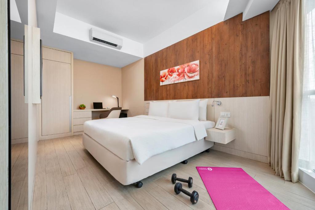 - une chambre avec un lit blanc et un tapis rose dans l'établissement Oasia Suites Kuala Lumpur by Far East Hospitality, à Kuala Lumpur