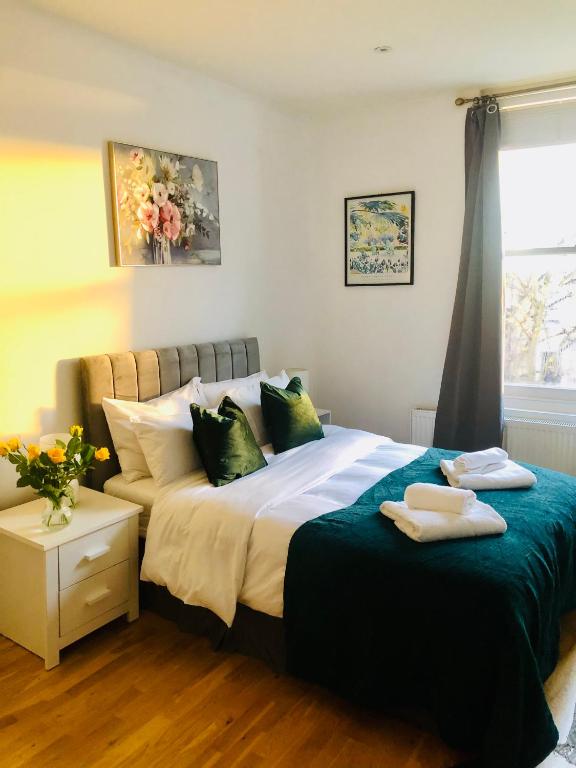 a bedroom with a large bed with towels on it at 20 min to central London- 2 bedrooms apartment in London