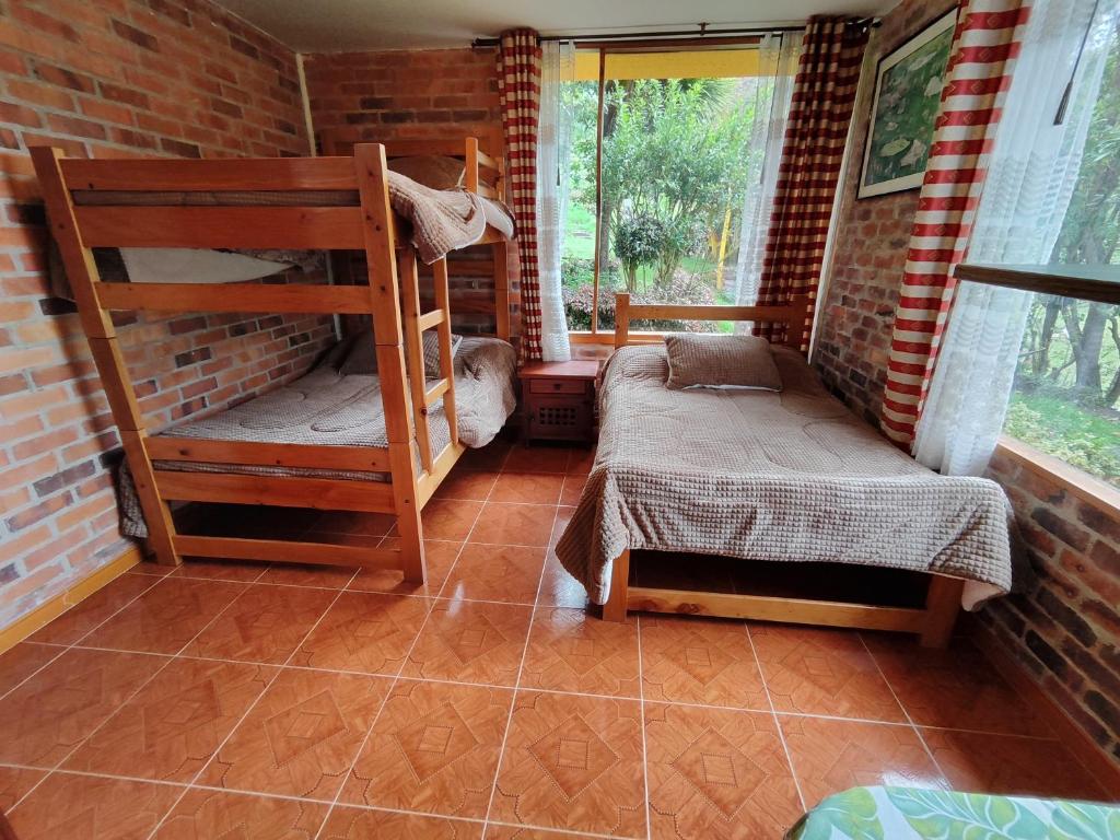 a room with two bunk beds and a window at Bed&Breakfast - Mirador de San Marcos in Paipa
