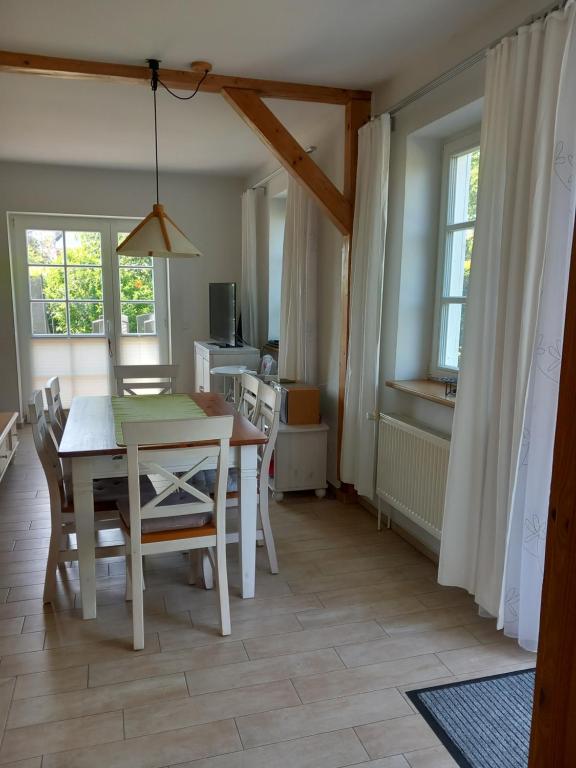 een keuken en eetkamer met een tafel en stoelen bij Heideheimligkeit in Gelbensande