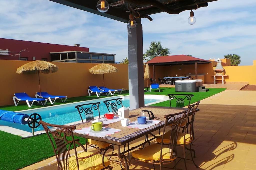a patio with a table and chairs next to a pool at Luxury Villa at Golf Course in Costa de Antigua