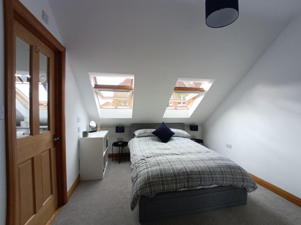 1 dormitorio con 2 tragaluces y 1 cama. en Entire modern cottage close to beach - Pet friendly en Gosport
