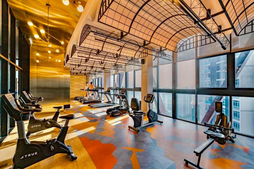 a gym with a row of treadmills and exercise bikes at Scarletz Suites KLCC by M Suites in Kuala Lumpur