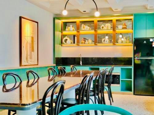 a kitchen with a bunch of chairs and a counter at Scarletz Suites KLCC by M Suites in Kuala Lumpur