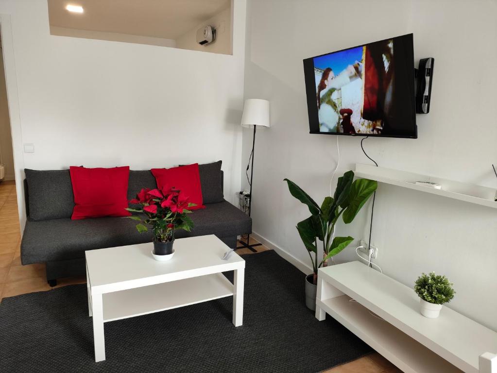 a living room with a couch and red pillows at San Centro Airport IFEMA Wizink Metropolitano Apartments in Madrid