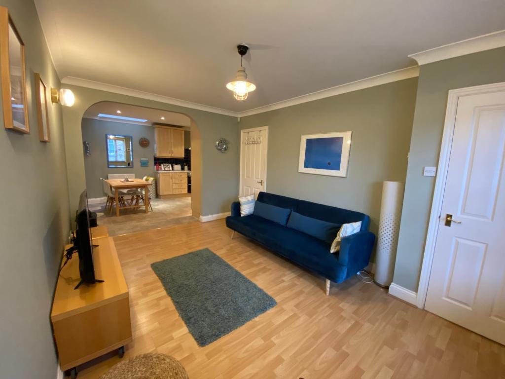 a living room with a blue couch and a table at Harbour Mews Central Location Near Beach in Whitstable