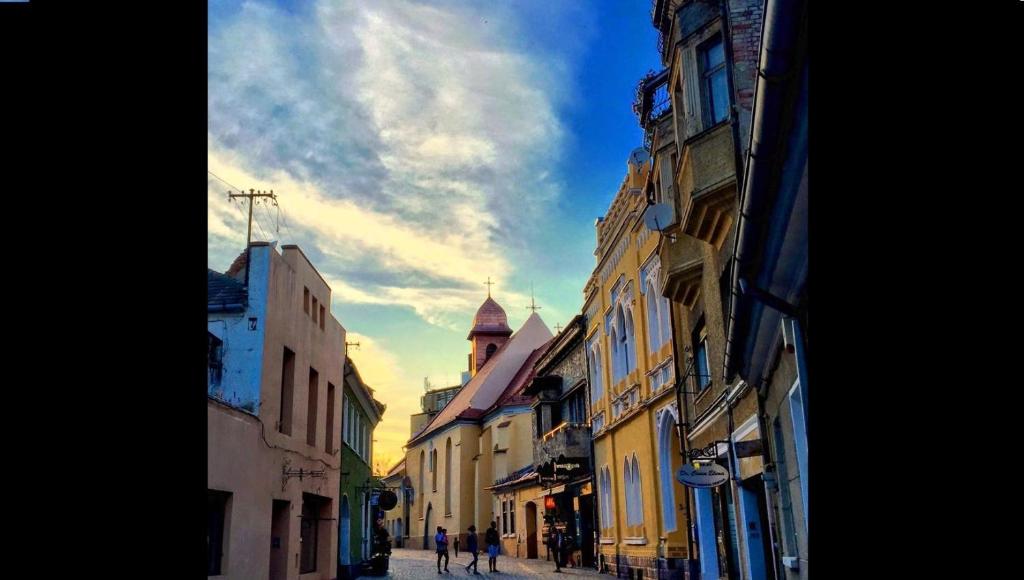 a group of buildings on a city street at Aki Apartment in Braşov