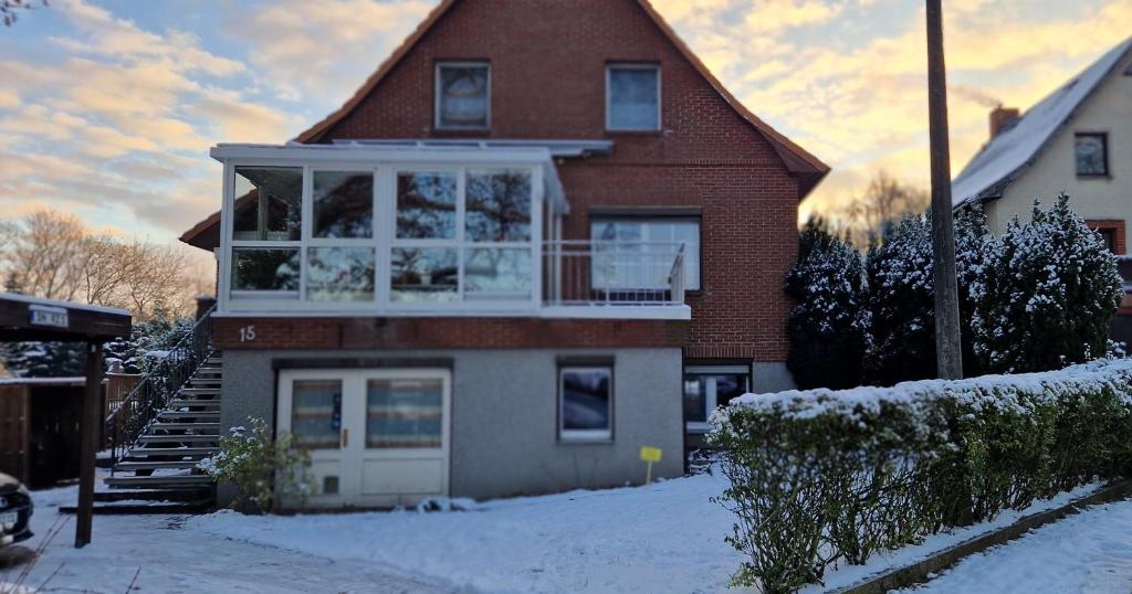 ein Haus mit Schnee auf dem Boden davor in der Unterkunft FeWo Schwerin-Zippendorf mit Sauna und Strandnähe, 4 km bis zur City in Ostorfer Hals