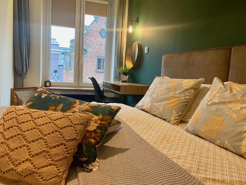 Hotel Apartament ZIELONY lub BURSZTYNOWY z parkingiem Stare Miasto Gdańsk, a bedroom with a bed with pillows and a window at Apartament ZIELONY lub BURSZTYNOWY z parkingiem Stare Miasto Gdańsk in Gdańsk