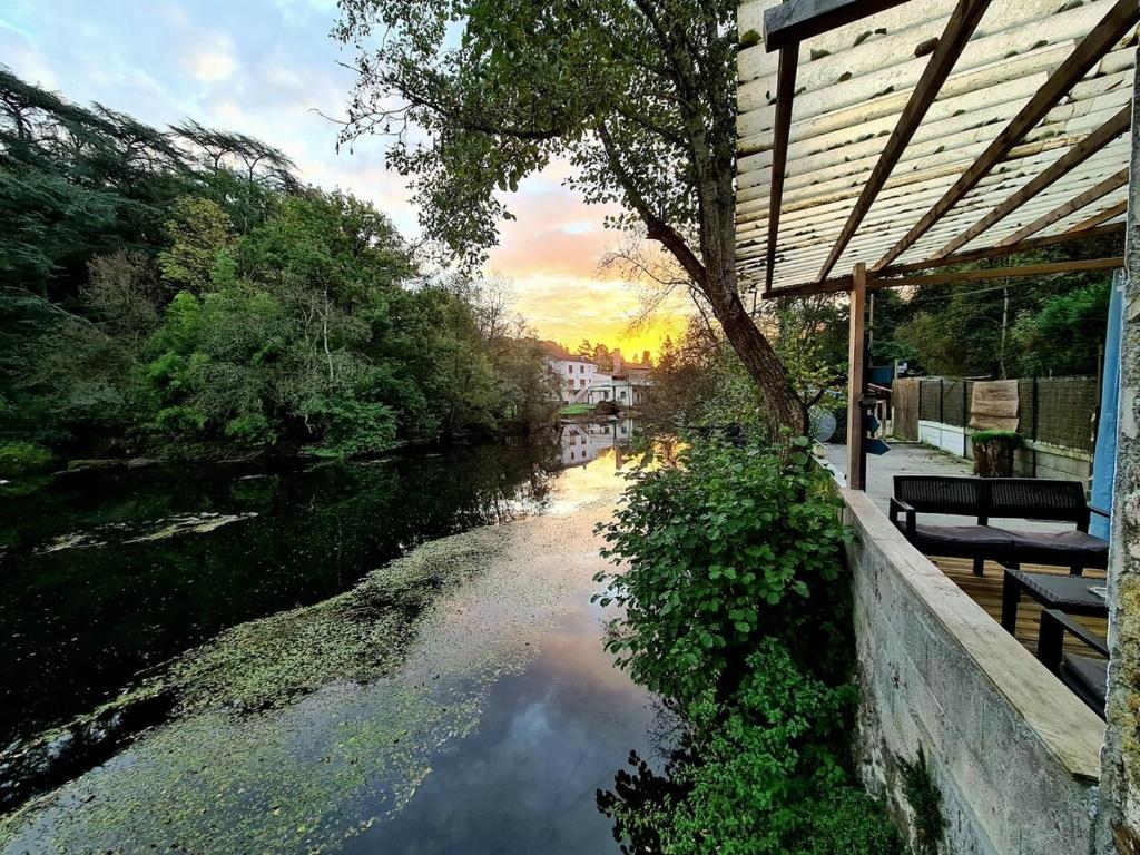 - une vue sur une rivière à côté d'un bâtiment dans l'établissement PETIT PARADIS, à La Bruffière