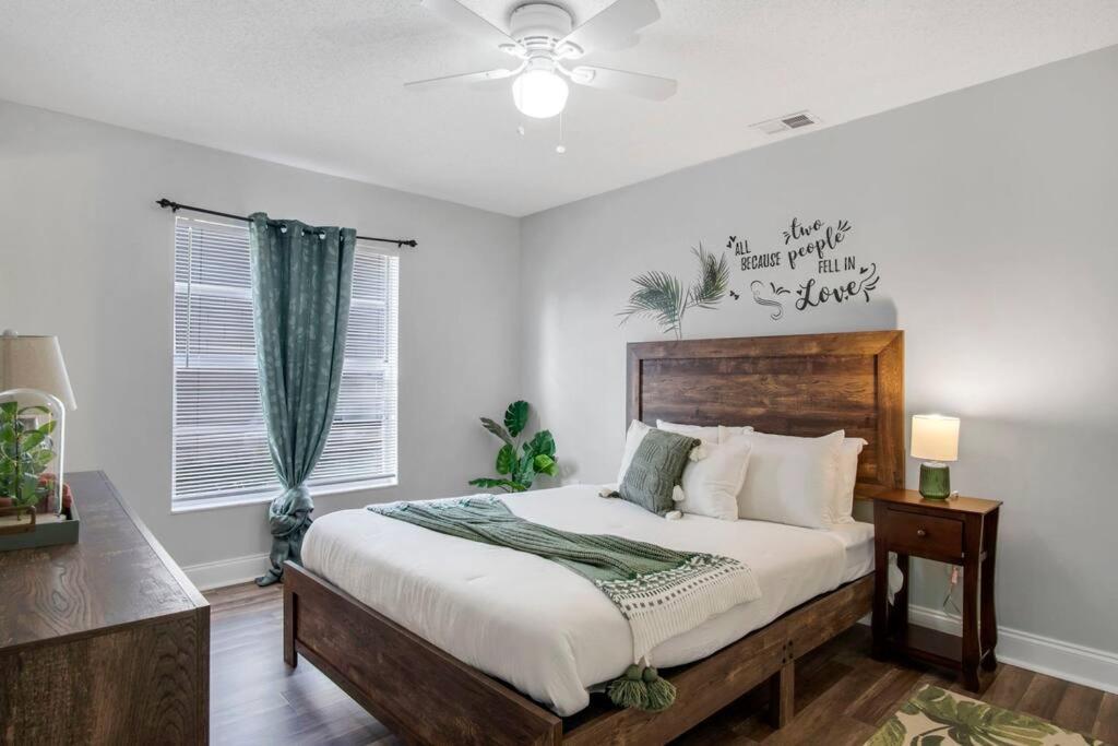um quarto com uma cama e uma ventoinha de tecto em Cozy Orlando Stay With garden & Next to Disney Springs em Orlando