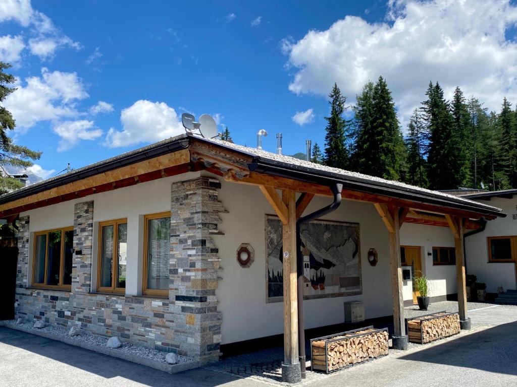 a stone building with a roof with trees in the background at Mountain Apart Katzenkopf in Leutasch