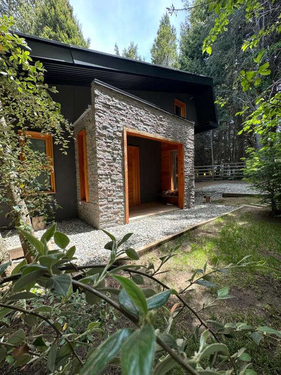a stone house with a black roof at Orn, Chill Out Houses By A.M.A in San Carlos de Bariloche